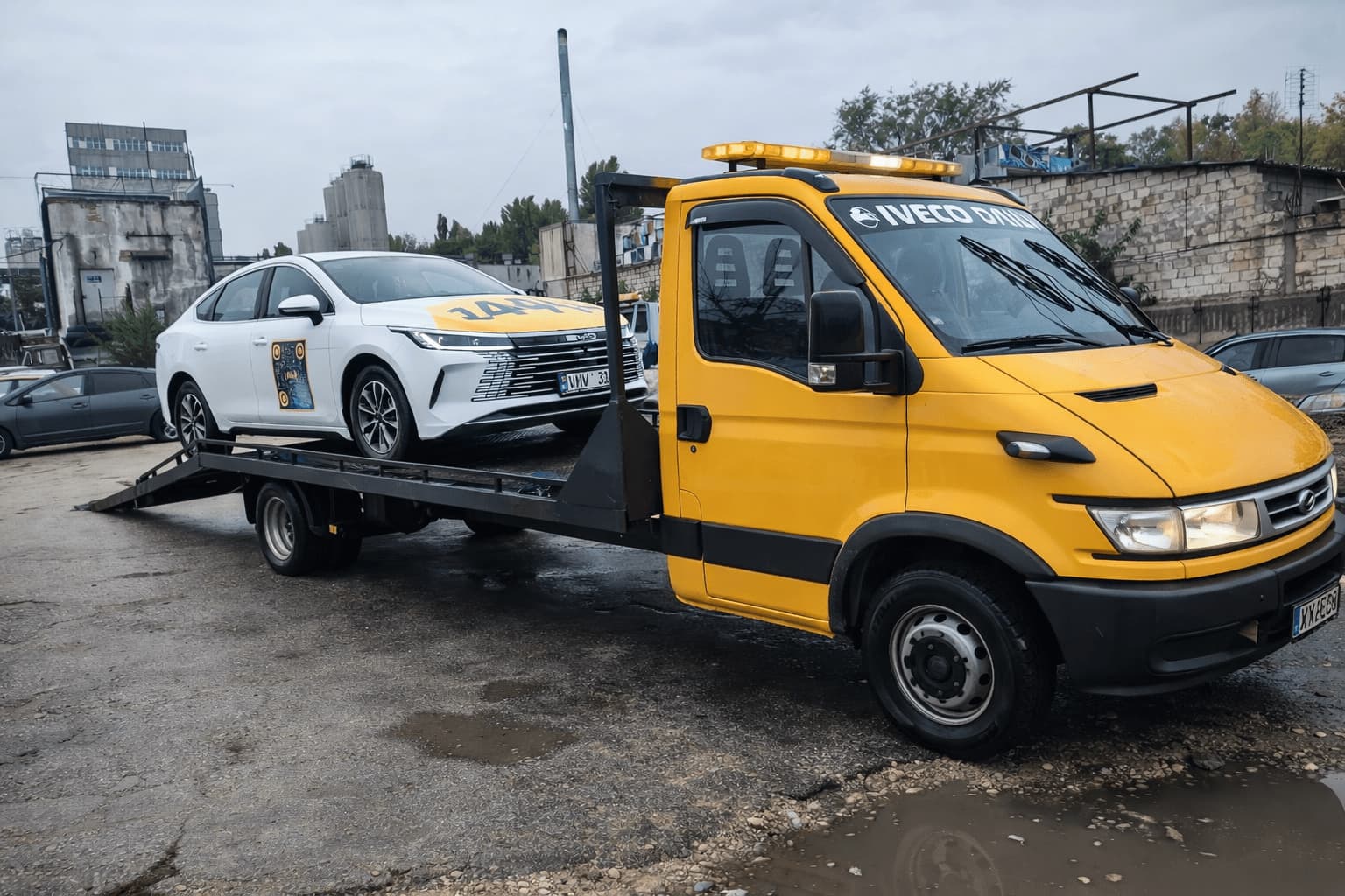 Evacuator auto transportând autoturism pe platformă în Chișinău, intervenție non-stop